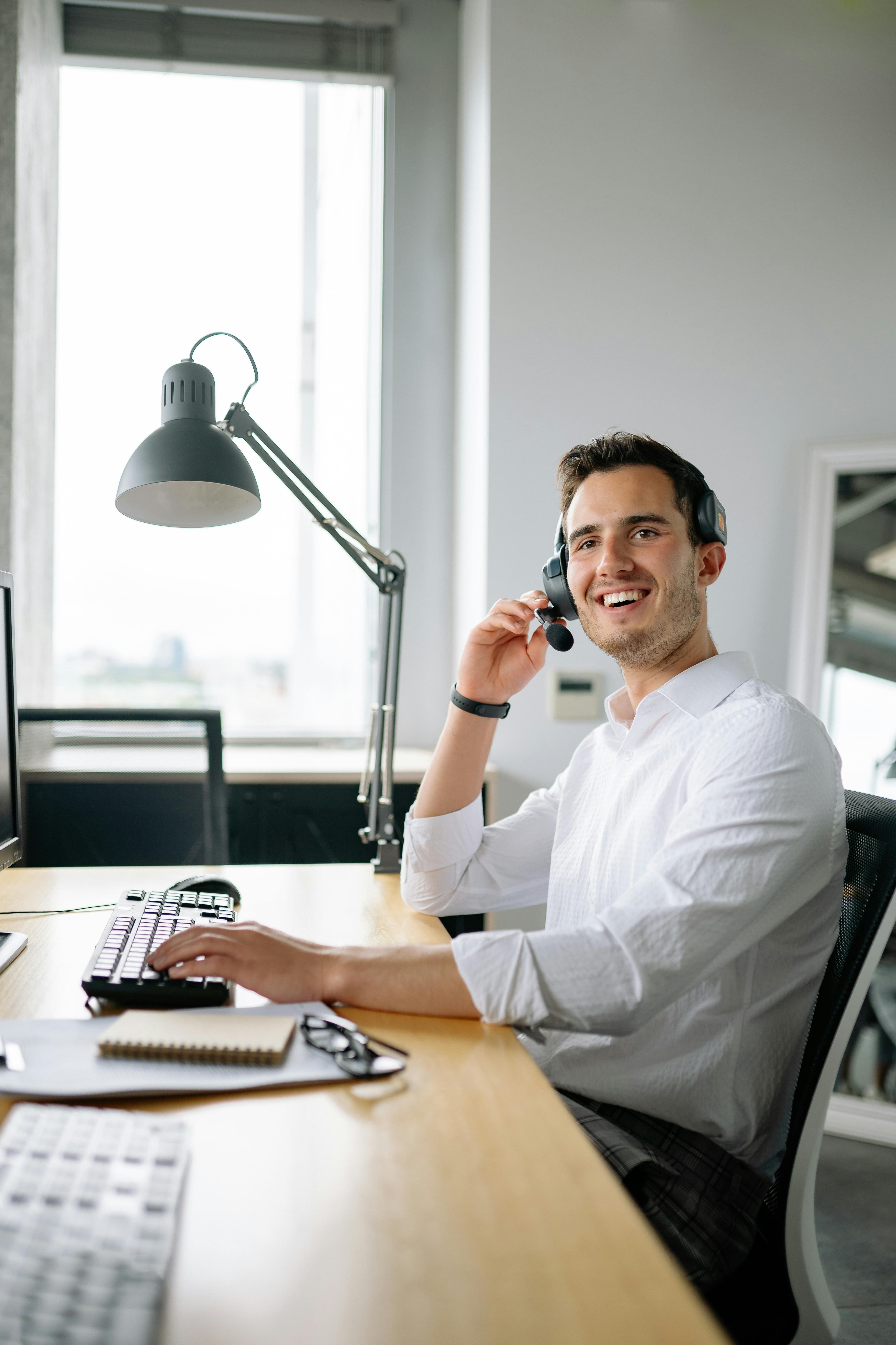 Sales support representative speaking with a client from a headset workstation.